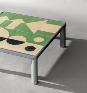 Tabletop with green, white, and black tiles supported by a silver metal frame and legs.