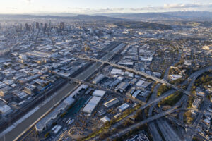 Sweeping birds eye view of the Los Angeles Sixth Street Viaduct within a large city.