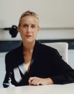 A person in a black jacket, sitting behind a table.